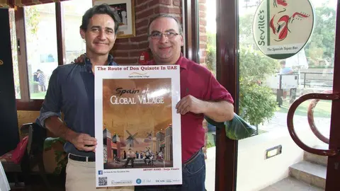 Raúl Simón -izquierda- y Mariano Andrés exhiben el cartel en el restaurante Seville´s, establecimiento donde se encuentra la primera pista. (EL CORREO)