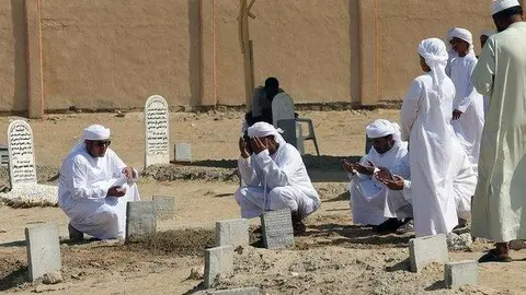 Oraciones en el cementerio de Fujairah por el soldado fallecido.