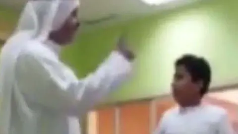 Una captura del vídeo con el profesor y el niño de un colegio de Ajman.