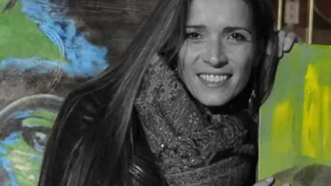 La artista Olga Dacha junto a su obra.