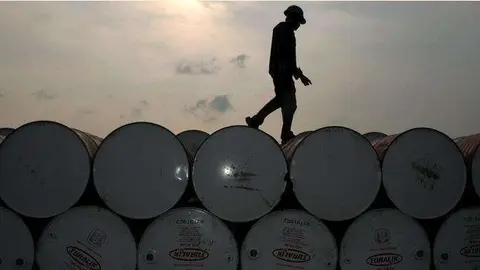 Un trabajador camina por barriles de petróleo. (Fuente externa)
