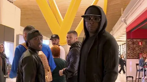 Benzema con mochila rodeado por sus amigos en el aeropuerto de Barajas.,