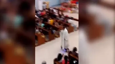 El sacerdote por el pasillo de la iglesia.