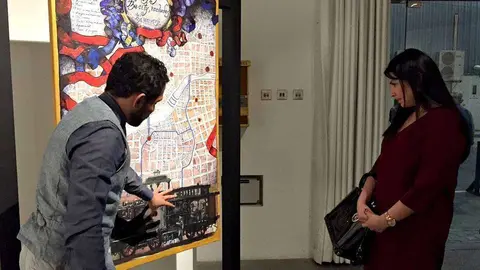 Fernández le muestra el mapa de su ciudad a Claudia Guevara, cónsul general adscrita. (EL CORREO)