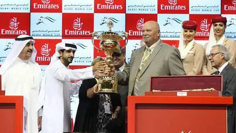 El jeque Hamdan entrega la copa al propietario de California Chrome. (Wam)
