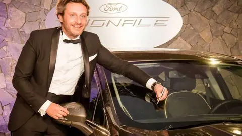 Juan Peña firma un autógrafo en un coche.