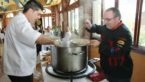 Mariano Andrés -derecha- y José Vicente sirven la fabada en el Día de Asturias. (EL CORREO)