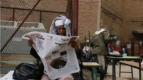 Un yemení lee el periódico en un mercado en Saná.