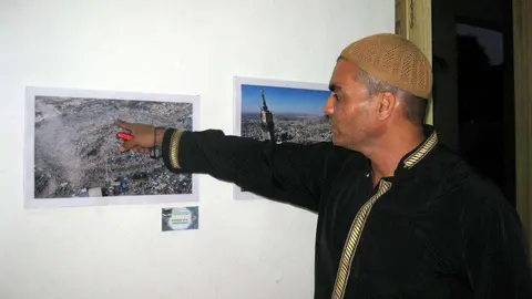 Haiji Isa muestra varias de las imágenes que integran la exposición. (Sergio Martínez)