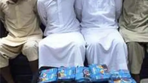 Los cuatro detenidos por tráfico de drogas en Abu Dhabi, junto al hachís confiscado.