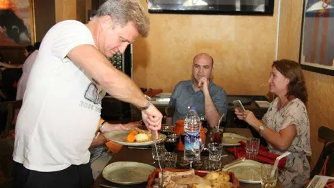 Marco Antonio Urios sirve entre sus compañeros de mesa el cocido. (EL CORREO)