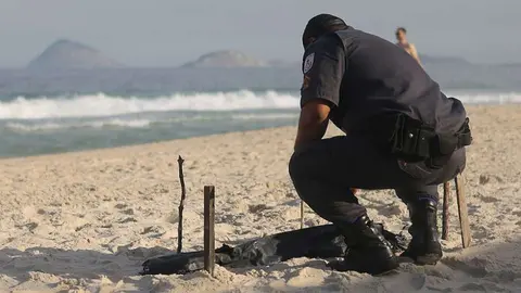 Un policía revisa la playa de Copacabana.