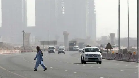Un trabajador cruza una carretera en Dubai. (Fuente externa)