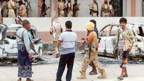 Los yemeníes armados junto a los coches bomba en Adén.