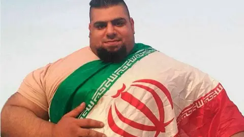 Una imagen del Hércules Persa envuelto en la bandera de su país.