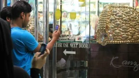 Turistas toman imágenes en el zoco de Dubai del anillo de oro más grande del mundo. (EL CORREO)