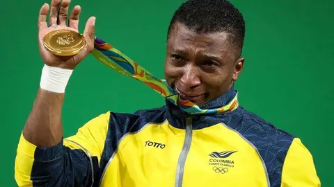 El atleta colombiano Óscar Figueroa muestra la medalla de oro lograda en Río en halterofilia. (Efe)