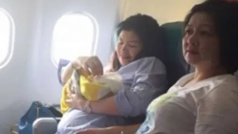 La madre y el bebé en el avión, después del parto.