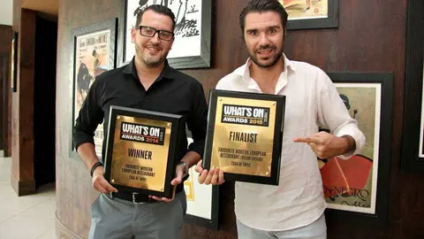 Marc Ledesma -izquierda- y Borja Vela muestran anteriores reconocimientos de los premios What's On a Casa de Tapas. (EL CORREO)
