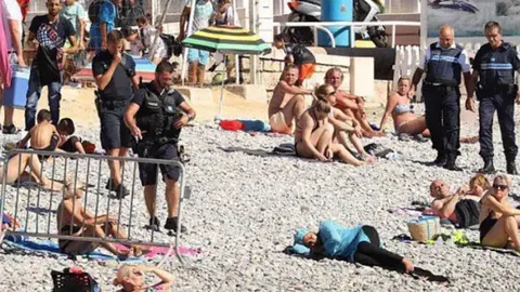 Los agentes franceses y la mujer del birkini.