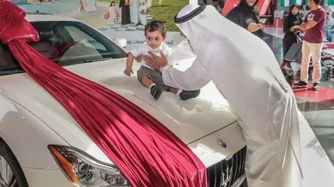 El bebé de once meses posa con el deportivo conseguido.