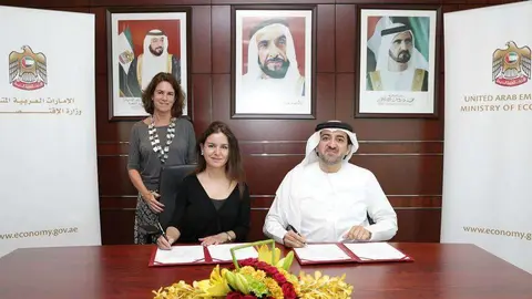 Mohammed Ahmed Bin Abdul Aziz Al Shehhi y Eva Martín, en el momento de la firma del acuerdo. De pie, María José Fernández.