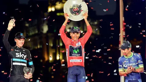 El colombiano Nairo Quintana levanta la copa como vencedor de la Vuelta a España con su paisano Esteban Chaves, tercero en la prueba ciclista, a su derecha. (@NoticiasRCN)