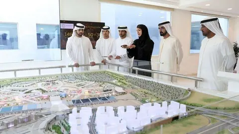 La comitiva gubernamental observa la maqueta del recinto. (WAM)