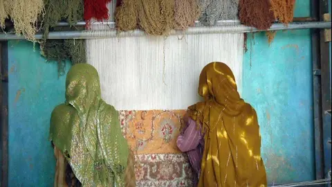 Mujeres afganas confeccionan una alfombra.