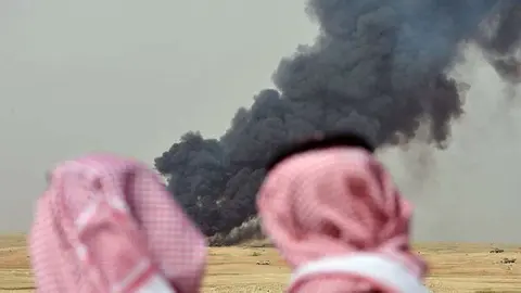 En la imagen de Reuters dos saudíes observan los efectos de los bombardeos.