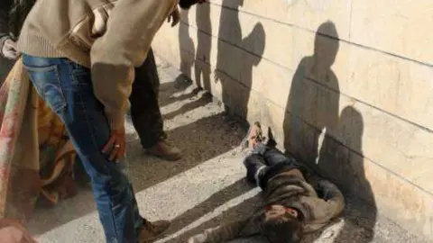 En la imagen de AFP, un hombre observa a un niño muerto en un barrio de Alepo.