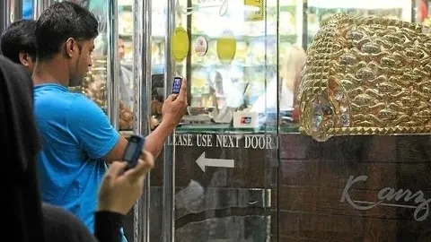 Curiosos fotografían el anillo de oro más grande del mundo en el zoco de Dubai (EL CORREO).
