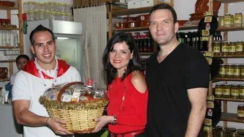 Sergio González entrega la cesta de Navidad a María Beykovsky, quien acudió junto a su marido al pabellón de España en el Global Village. (E.C.)