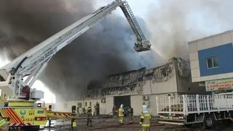 Los bomberos trabajan en la extinción del fuego en un almacén de Ajman. (Defensa Civil de Ajmán)