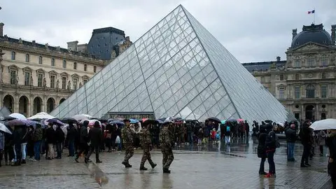 Turistas y soldados junto al Museo del Louvre en París. 