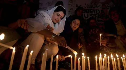 Mujeres pakistaníes encienden velas en homenaje a las víctimas del último ataque en un templo del país.