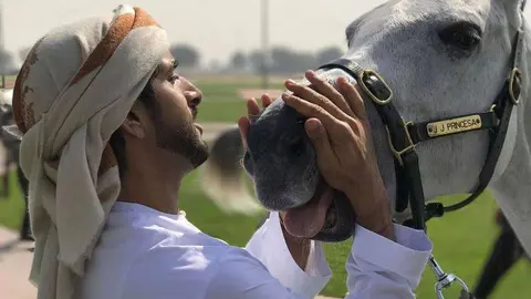 El príncipe heredero de Dubai acaricia a uno de sus caballos.