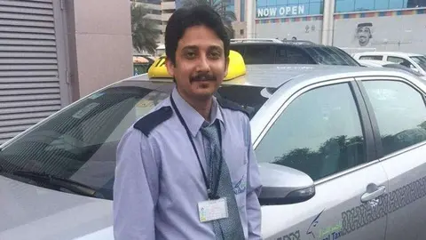 El chef pakistaní junto al taxi que conduce.