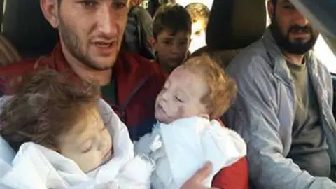 Un padre sirio con sus hijos mellizos fallecidos tras el ataque químico.