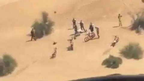 El turista español herido, junto a su grupo, grabado desde el aire por la Policía de Dubai.