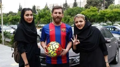 El doble de Messi posa con dos jóvenes iraníes.