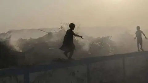 En la imagen de EFE unos niños jugando en un basurero en la India.