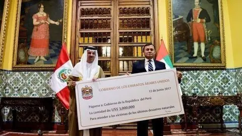 El embajador de Emiratos en Perú, Mohammed Yusouf Al Awadi, entrega un cheque al viceministro de Relaciones Exteriores de Peru, Nestor Francisco Popolizio. (WAM)