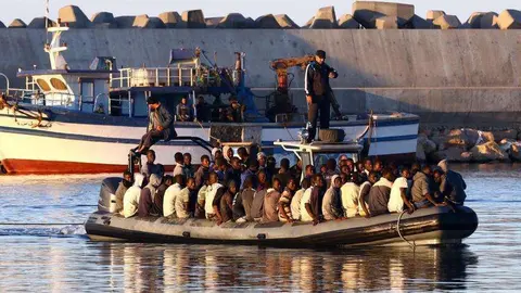 En la foto de AFP, inmigrantes navegan por el Mediterráneo.