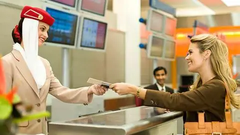 Una pasajera factura en un mostrador de Emirates. (Emirates Airlines)