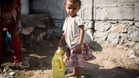 Una niña recoge agua en Yemen.