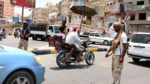 Las fuerzas de seguridad yemeníes inspeccionan los vehículos en un retén en Mukalla.