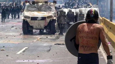 Un manifestante se enfrentan a la Guardia Nacional Bolivariana en Caracas ( Venezuela). EFE