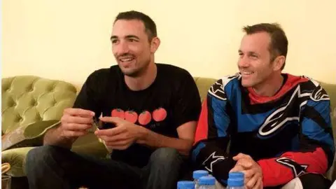 Los dos europeos posan en la casa de su salvador. (Policía de Sharjah)