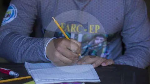 En la imagen un excombatiente de la FARC empuña un lápiz. (DONALDO ZULUAGA)